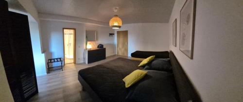 een woonkamer met een zwarte bank en een woonkamer met bij Haus Im Wald 