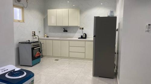 een keuken met een koelkast en een fornuis bij نسيم الربيع 2 للشقق المخدومة in Quai