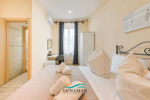 a bedroom with a large white bed with pillows at Affittacamere Lunamar in La Spezia
