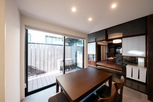 een eetkamer met een tafel en een groot raam bij Atlechia Gion Uji Villa アトレチア祇園 宇治別邸 in Uji