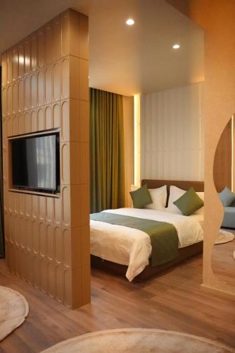 ein Schlafzimmer mit zwei Betten und einem Flachbildfernseher in der Unterkunft Dastan Grand Hotel in Jalal-Abad