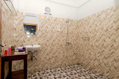 een badkamer met een wastafel en een douche bij Hotel Bonne Nuit in Labuan Bajo