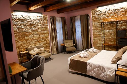 een slaapkamer met een bed en een stenen muur bij IL MOLINO del SIGNORE in Pergola