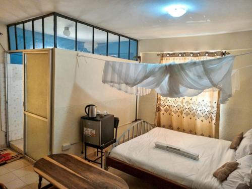 a small bedroom with a bed with a window at satelite view hotel in Webuye