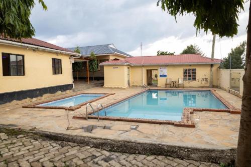 a swimming pool in front of a house at satelite view hotel in Webuye