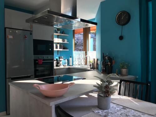 a kitchen with blue walls and a pink bowl on a counter at Villa Eva & Lilou Pod Rysianką in Żabnica