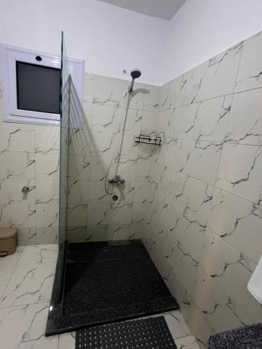 ein Bad mit einer Dusche und einem TV an der Wand in der Unterkunft Ali Baba Guest House in Luxor