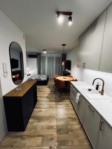 a kitchen with a sink and a table in a room at Marina Portovo in Gdańsk