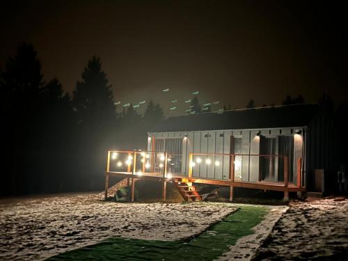 a house with lights on the side of it at night at Domek Jak z Obrazka in Sierpnica