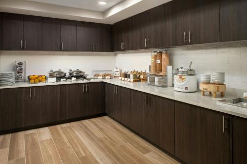 a kitchen with wooden cabinets and a counter top at Residence Inn by Marriott Atlantic City Airport Egg Harbor Township in Egg Harbor Township