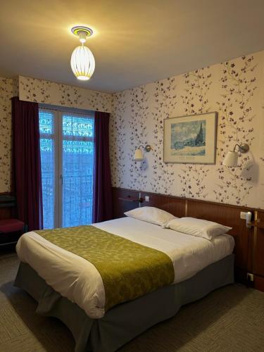a bedroom with a large bed in a room at Hotel le France, Redon in Redon