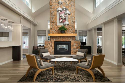 a lobby with a fireplace and chairs and a table at Residence Inn by Marriott Atlantic City Airport Egg Harbor Township in Egg Harbor Township
