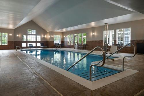 a large swimming pool in a large room with windows at Residence Inn by Marriott Atlantic City Airport Egg Harbor Township in Egg Harbor Township
