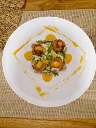 a white plate with food on a table at Palma De Maldives in Thoddoo