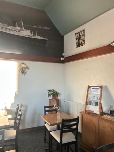 een eetkamer met een tafel en een schip aan de muur bij Hotel le France, Redon in La Celle-sous-Gouzon