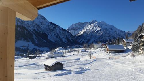 a snow covered village with a mountain in the background at Ahorn Chalet Mittelberg in Mittelberg
