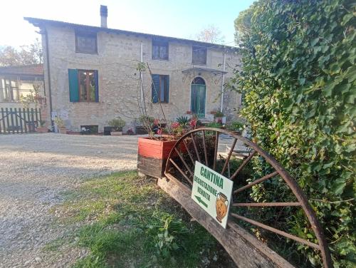 Ein Haus mit einem Schild vor einem hölzernen Rad in der Unterkunft Baduerughe - ValledelLago in Poggio Mirteto