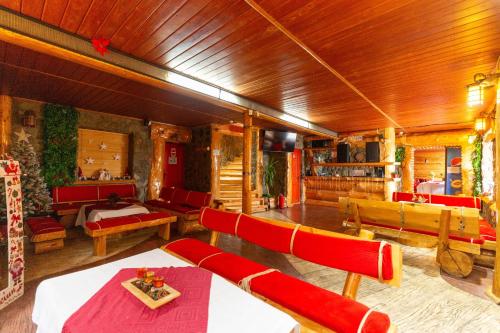a living room with red chairs and tables and a room with at Pensiunea Alpin SPA in Ranca