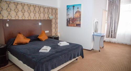 una camera da letto con un letto con due asciugamani sopra di Hotel Parc a Onești