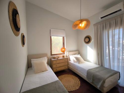 une chambre avec deux lits et une fenêtre dans l'établissement Villa Phos, à Gouves