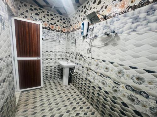 a bathroom with a toilet and a sink in it at Uthaya Guest House in Mullaittivu