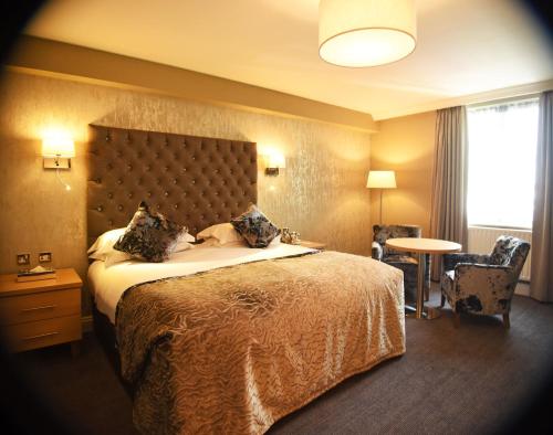a hotel room with a large bed and a table at Park Inn by Radisson Shannon Airport in Shannon