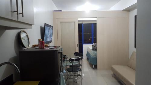 ein Wohnzimmer mit einem Schreibtisch und Stühlen im Zimmer in der Unterkunft FinkSea @ Sea Residences in Manila