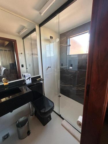 a bathroom with a glass shower and a sink at Chalé Alto da Copaiba in Cunha