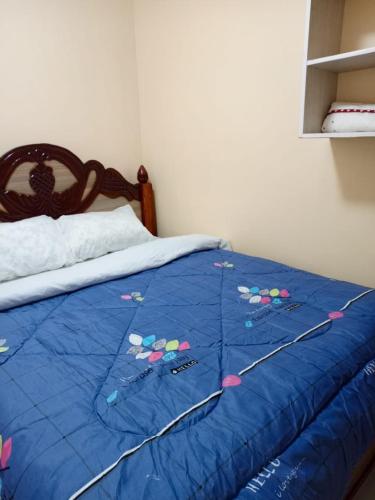 een bed met een blauw dekbed met vliegers erop bij EsMash Studio Machine lanet Nakuru in Nakuru