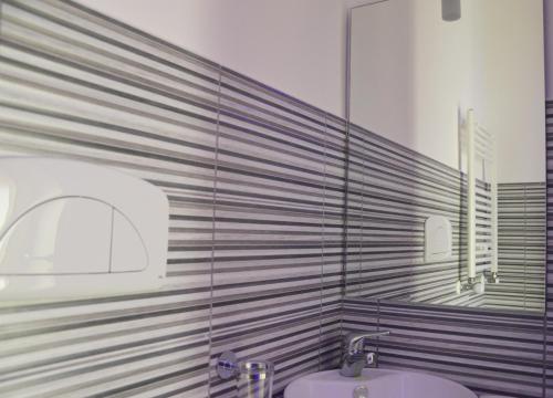 ein Badezimmer mit Waschbecken und Spiegel in der Unterkunft Iris Inn in Salerno