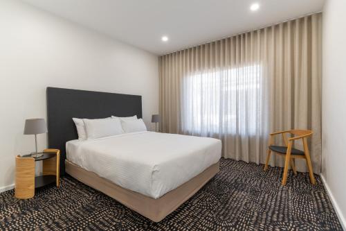a bedroom with a large bed and a window at Esplanade Apartments at West Beach in Adelaide