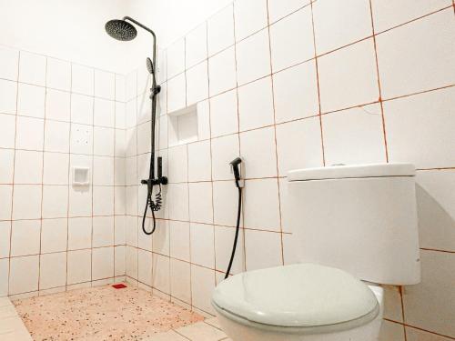 a bathroom with a toilet and a shower at MiTS Youth Hostel in Bandung