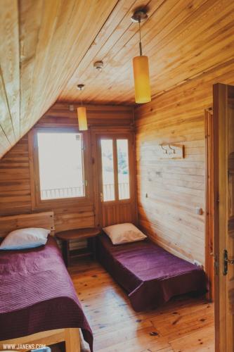a bedroom with two beds in a wooden cabin at Pirts Rudzupuķes in Svente