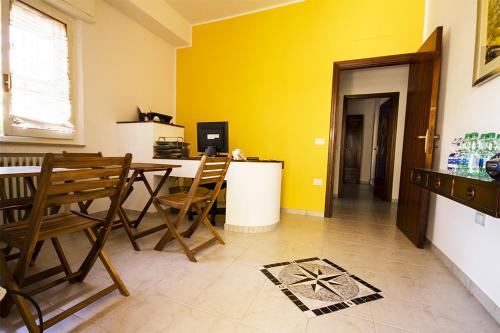 a room with a table and chairs and a yellow wall at Il Tiglio in Fano