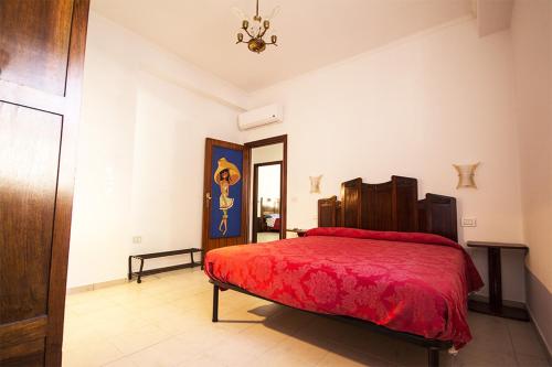 um quarto com uma cama vermelha e um lustre em Il Tiglio em Fano