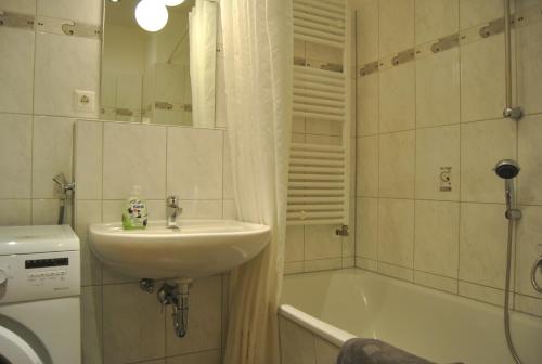 a bathroom with a sink and a bath tub at Adoreo Apartments & Suites in Leipzig