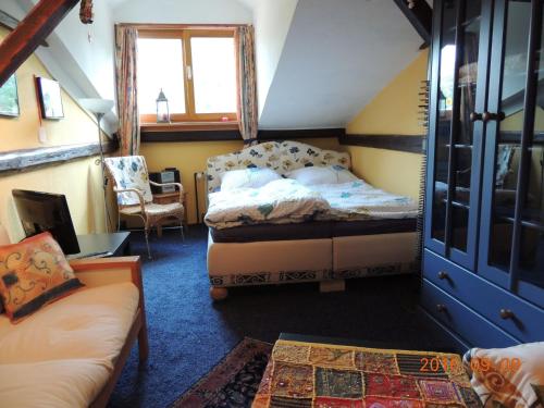 ein Schlafzimmer mit einem Bett und einem Stuhl in einem Zimmer in der Unterkunft Reiterhof Aumühle in Oberaula