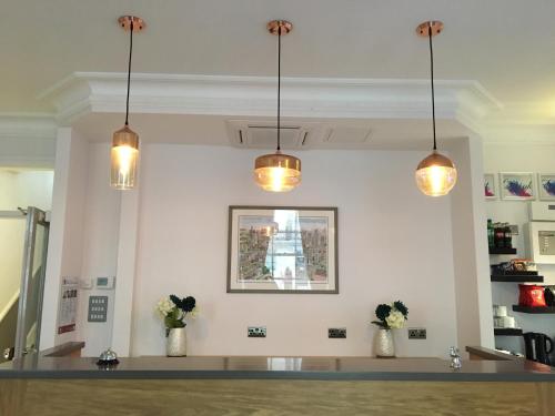 a room with three lights hanging from the ceiling at The Beverley Hotel London - Victoria in London