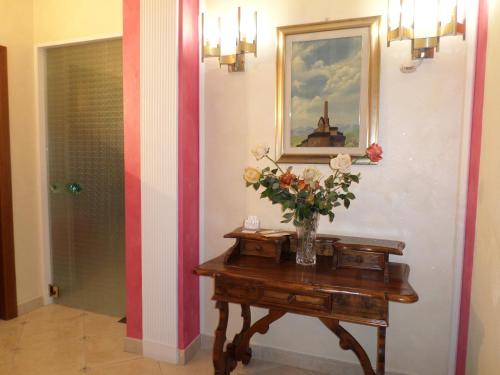 a vase of flowers on a table in a hallway at B&B COLOSSEO in Cosenza