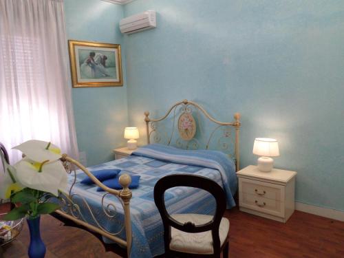 1 dormitorio azul con 1 cama y 1 silla en B&B COLOSSEO, en Cosenza