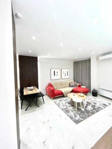 un soggiorno con un divano rosso e un tavolo di Iris Apartment II Livadeia a Levádeia