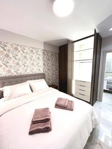 een slaapkamer met een wit bed met twee handdoeken erop bij Iris Apartment II Livadeia in Levádeia