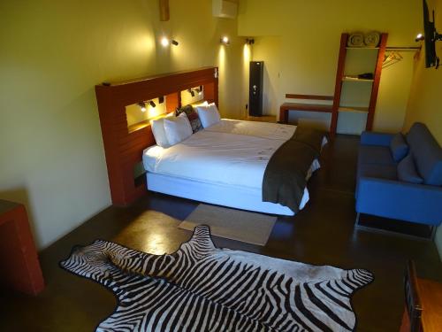 a hotel room with a bed with a zebra print on the floor at Auas Safari Lodge in Windhoek