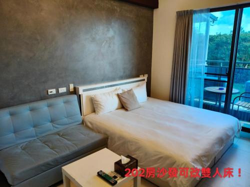 ein Schlafzimmer mit einem großen Bett und einer Couch in der Unterkunft Fun B&B in Altstadt von Hengchun