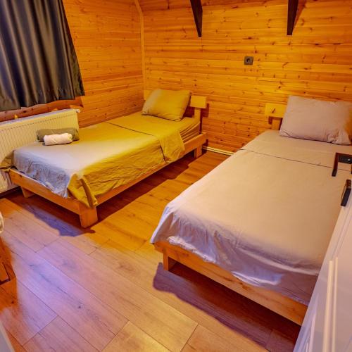 a room with two beds in a wooden cabin at Bugi Suit Bungalov in Erenköy