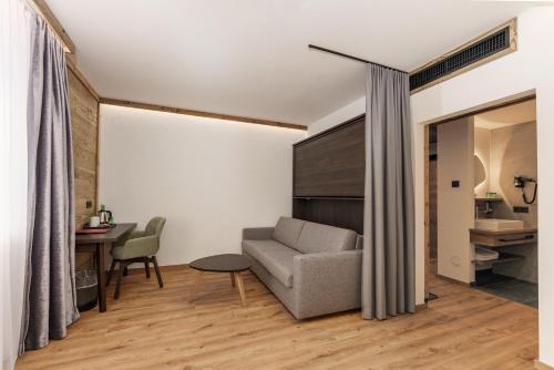 a living room with a couch and a table at Hotel Moser in Schladming