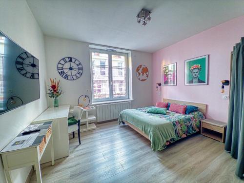 - une chambre avec un lit, un bureau et des horloges dans l'établissement Beau Studio Neuf proche du centre et de Nausicaa, à Boulogne-sur-Mer