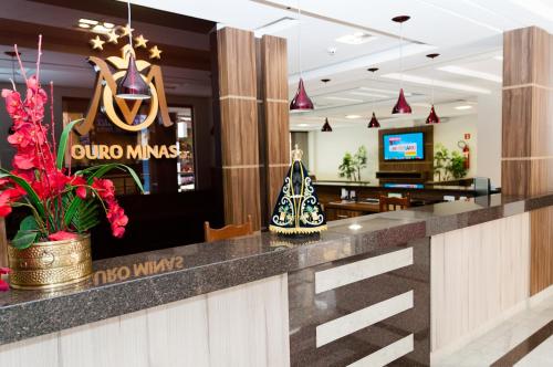 a lobby with a bar with a dung nurse sign at Ouro Minas Plaza Hotel in Aparecida