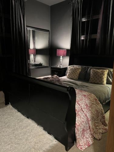 a bedroom with a bed with a large black headboard at The Nook at Ballyward Croft in Ardkeen