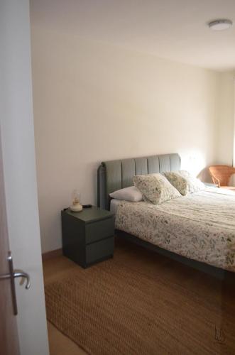 a bedroom with a bed and a side table at JayjAstur in Cangas de Onís
